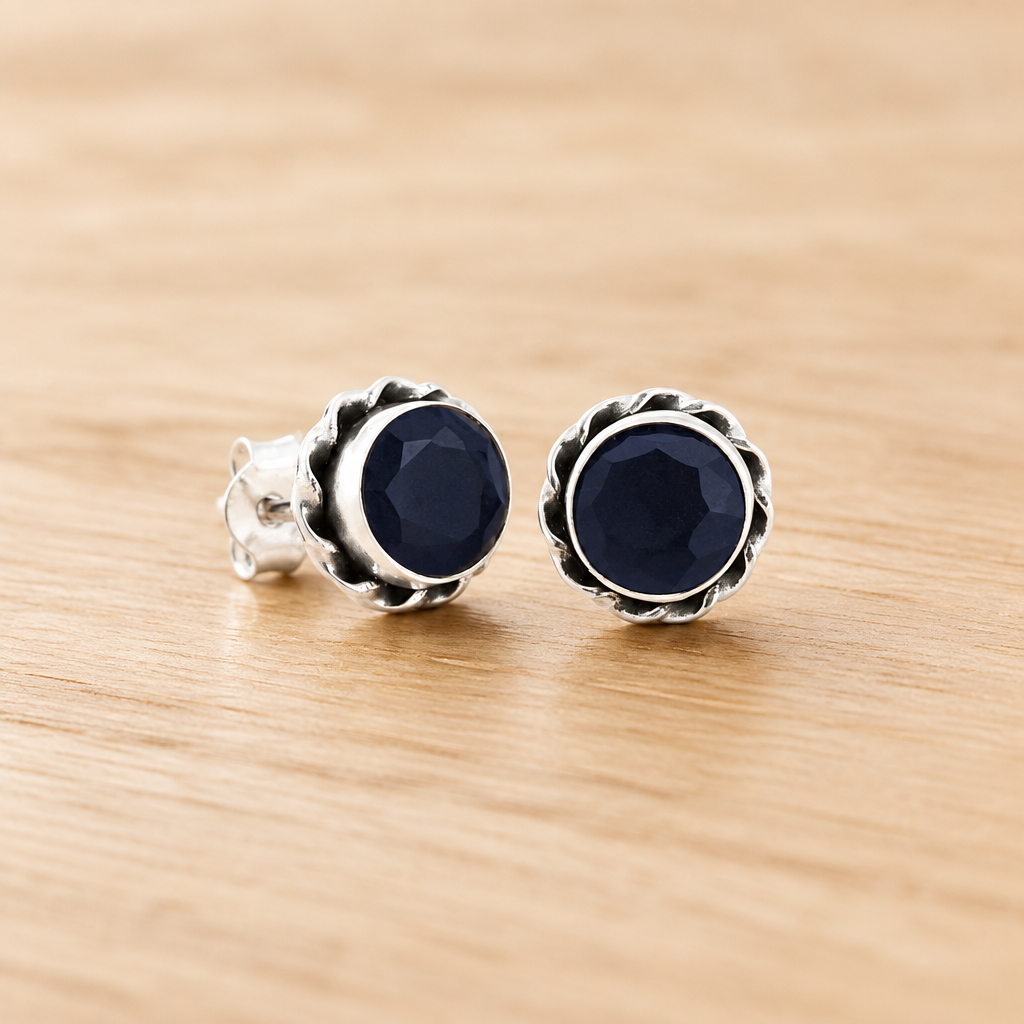 Pareja de pendientes azul oscuro sobre una mesa
